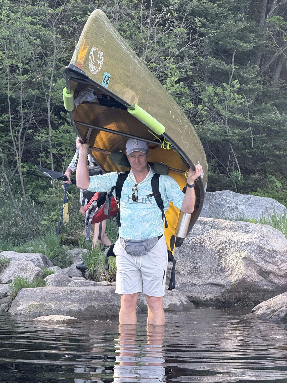 Paddler carrying a canoe over a rocky portage in the Boundary Waters